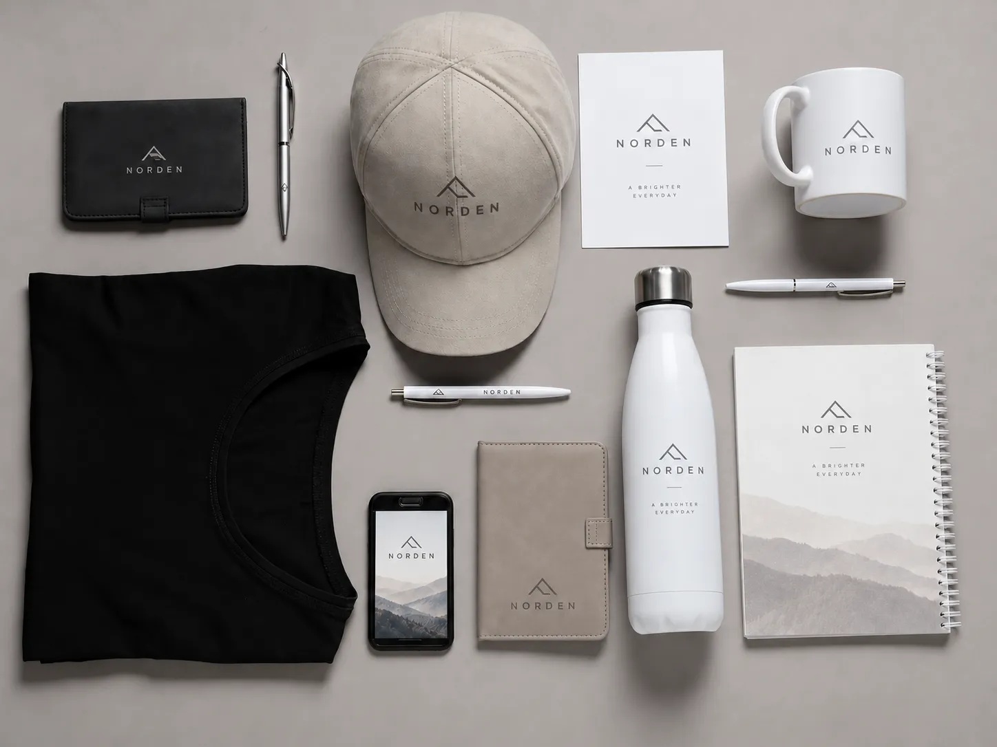 Branded merchandise mockups: a cap, mug, water bottle, notebook, pens and a T-shirt carrying one logo